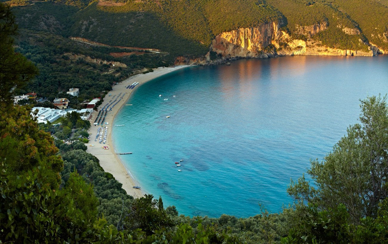 The photo shows Lichnos beach and its resort setting on the Ionian Sea near Parga, Greece.