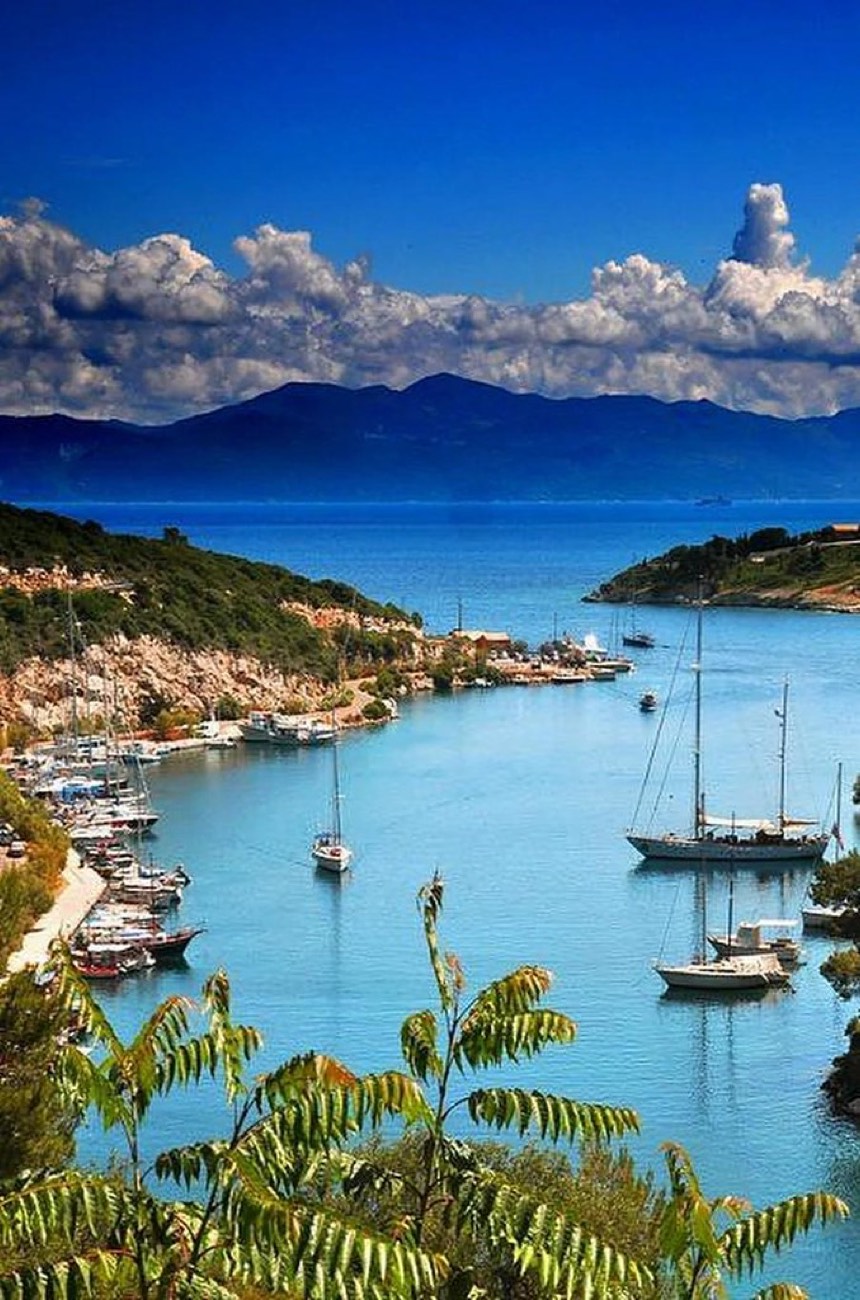 Gaios harbour on the island of Paxos, Greece, with boats moored along the waterfront channel.