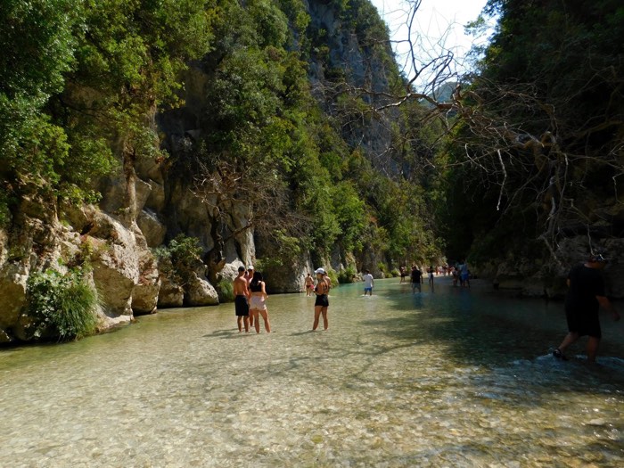 The clear turquoise water of the Acheron Springs gorge near Glyki, Epirus, Greece, winding through a forested limestone canyon.