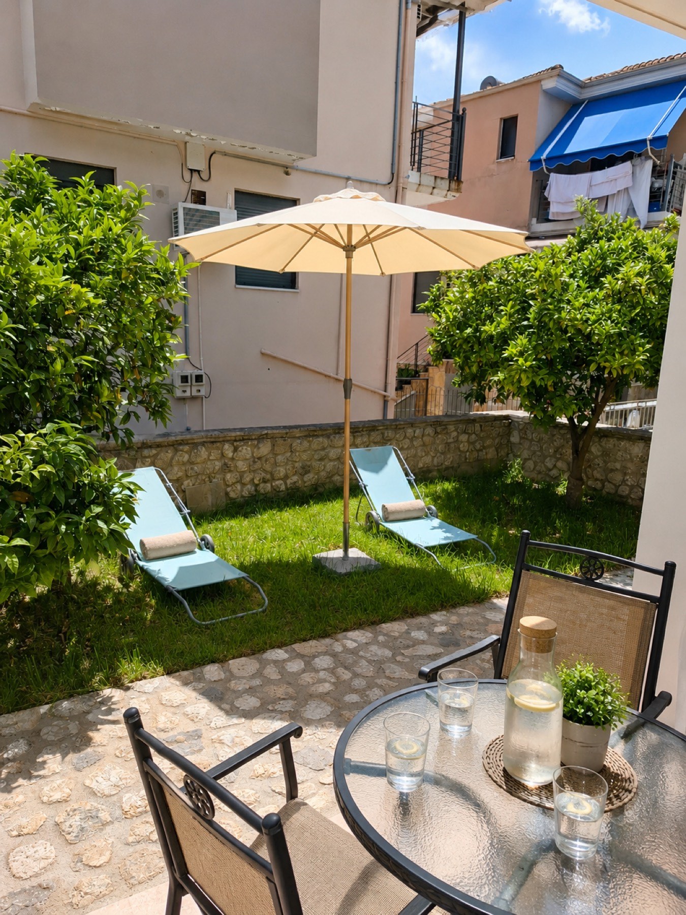 Private lawn garden with sun-loungers and orange trees at the Citrus Apartment