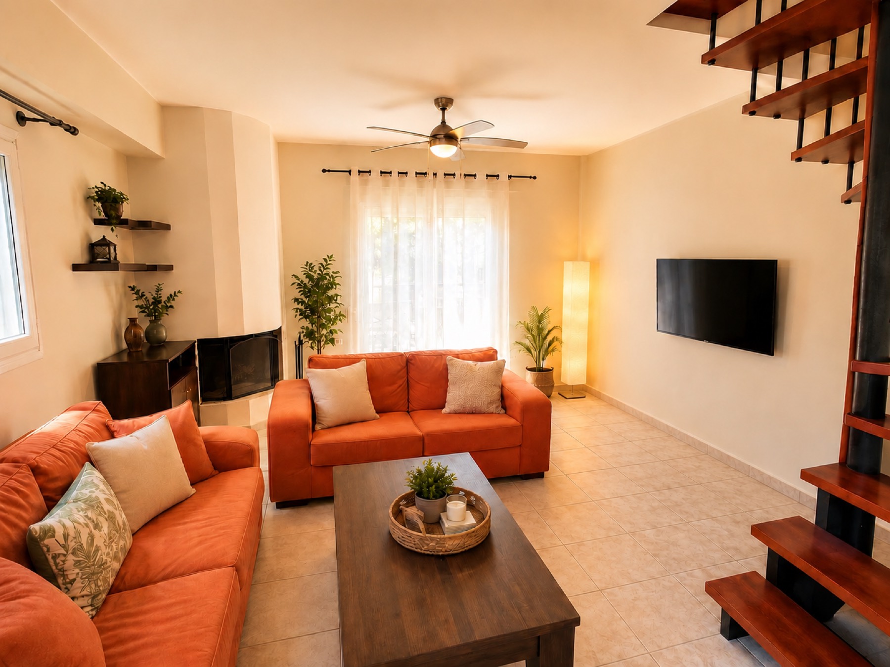Living room of The House with warm sofas, fireplace and internal staircase